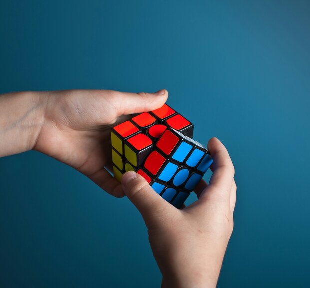 Ein  Mann stapelt den Rubik-Würfel